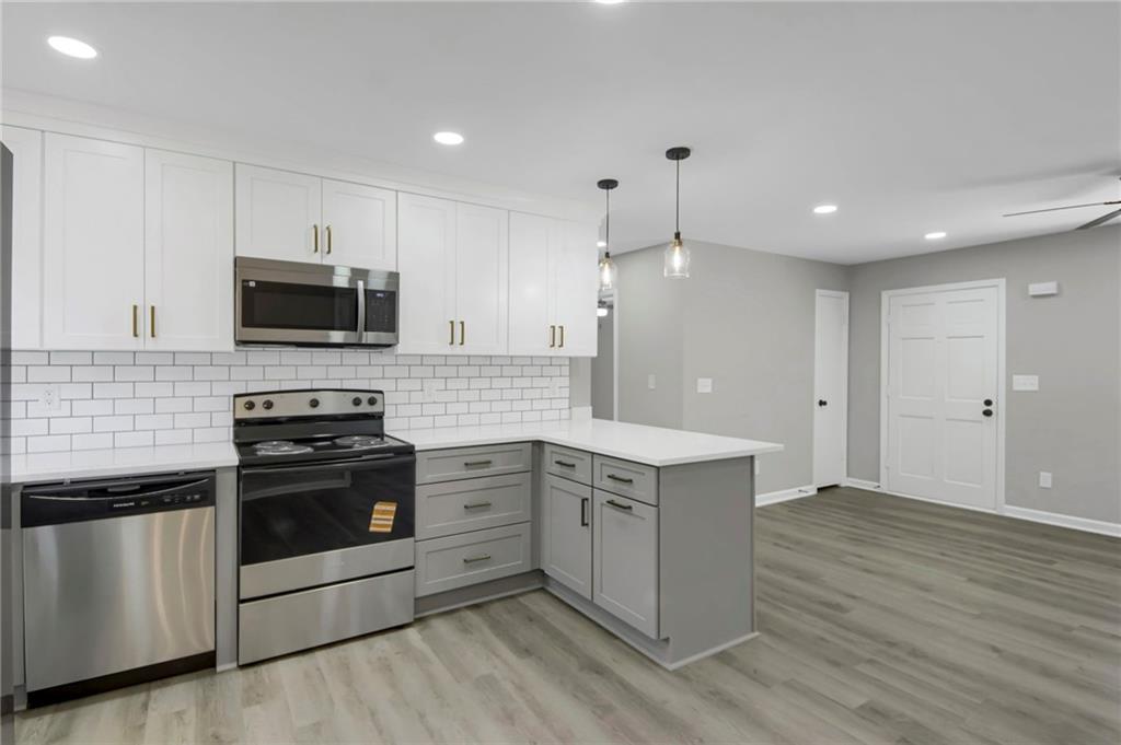 24 Echo Ridge Drive Powder Springs, GA 30127 - Photo 9 of 28 a large kitchen with stainless steel appliances granite countertop a stove a sink and a microwave