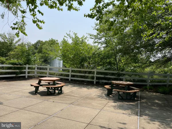 a swimming pool with some trees and seating area