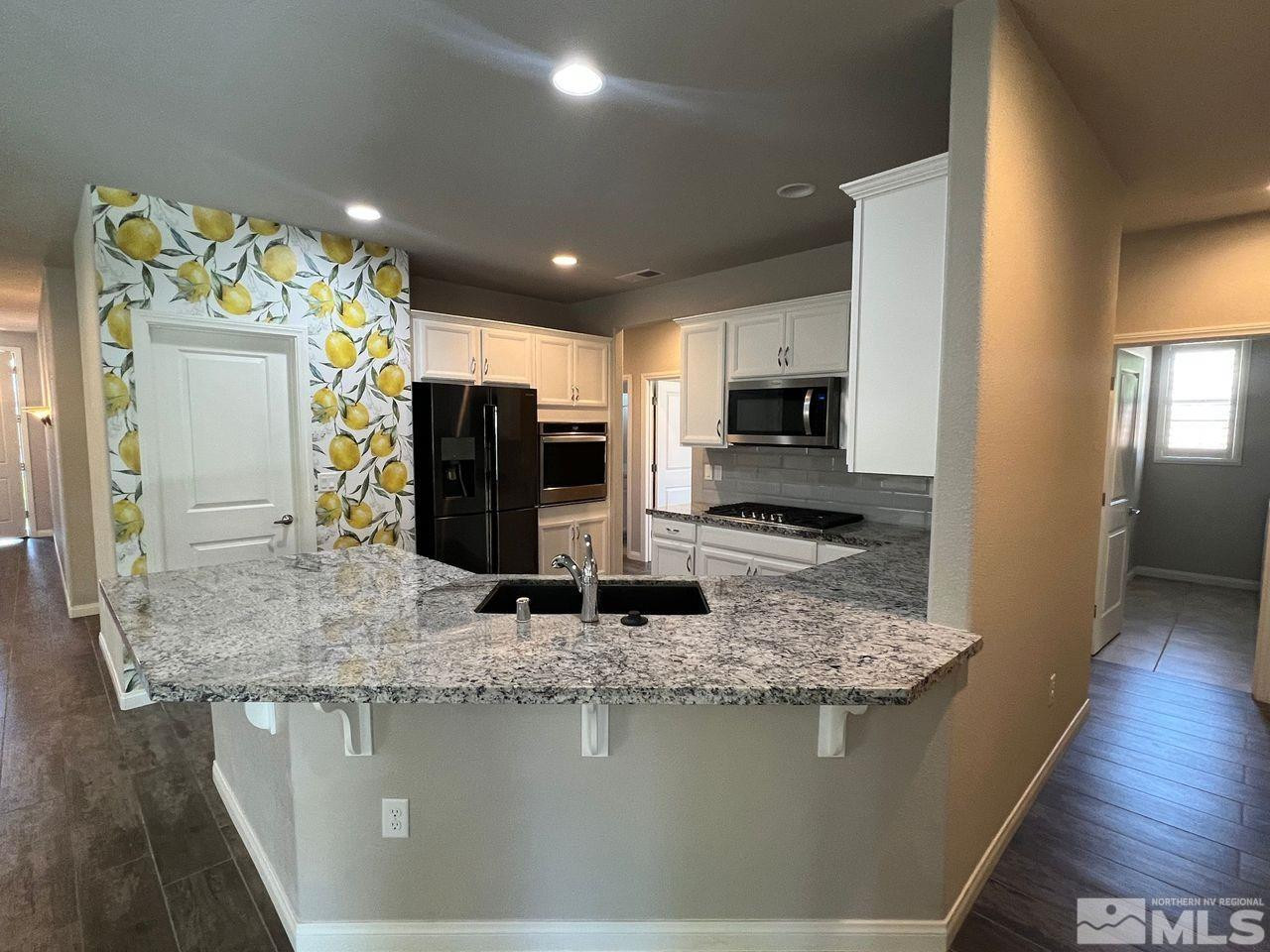 774 Sweet Briar Lane Sparks, NV 89436 - Photo 9 of 17 a kitchen with stainless steel appliances granite countertop a sink stove and refrigerator