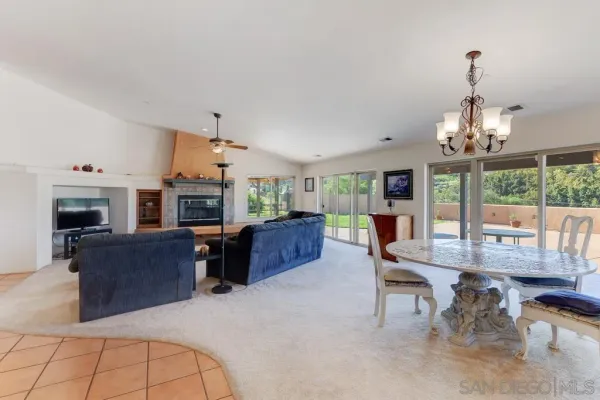 a living room with furniture a fireplace and a chandelier