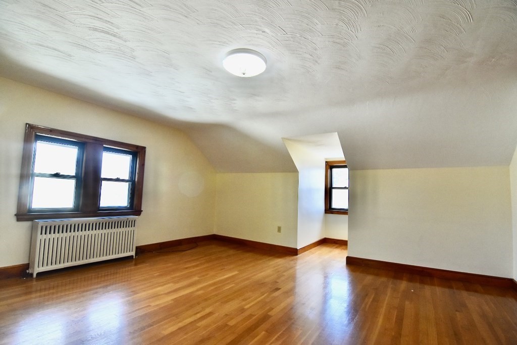 20 Hollis Avenue, Unit 5 Quincy, MA 02171 - Photo 7 of 14 an empty room with wooden floor and windows