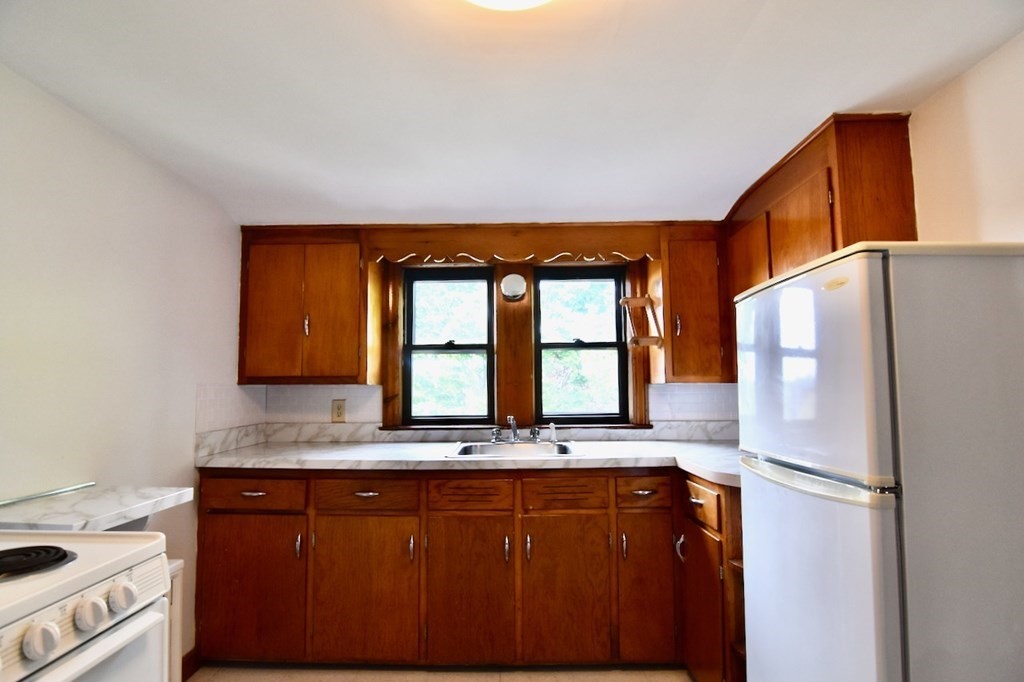 20 Hollis Avenue, Unit 5 Quincy, MA 02171 - Photo 10 of 14 a kitchen with granite countertop a refrigerator and a sink