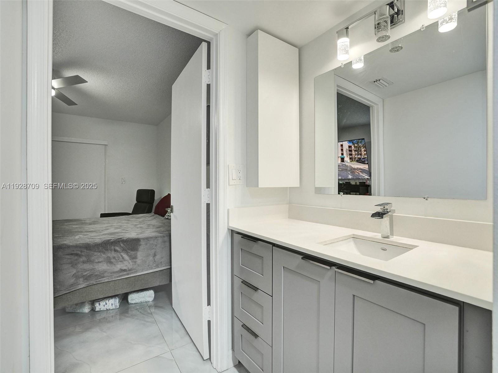 9470 Tangerine Place, Unit 207 Davie, FL 33324 - Photo 12 of 14 a bathroom with a sink and a mirror