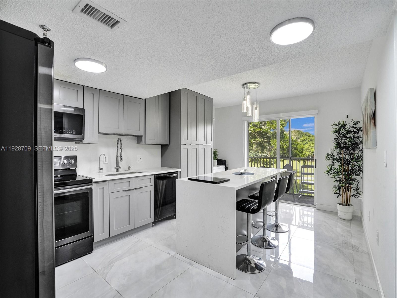 9470 Tangerine Place, Unit 207 Davie, FL 33324 - Photo 7 of 14 a kitchen with a sink stove and refrigerator