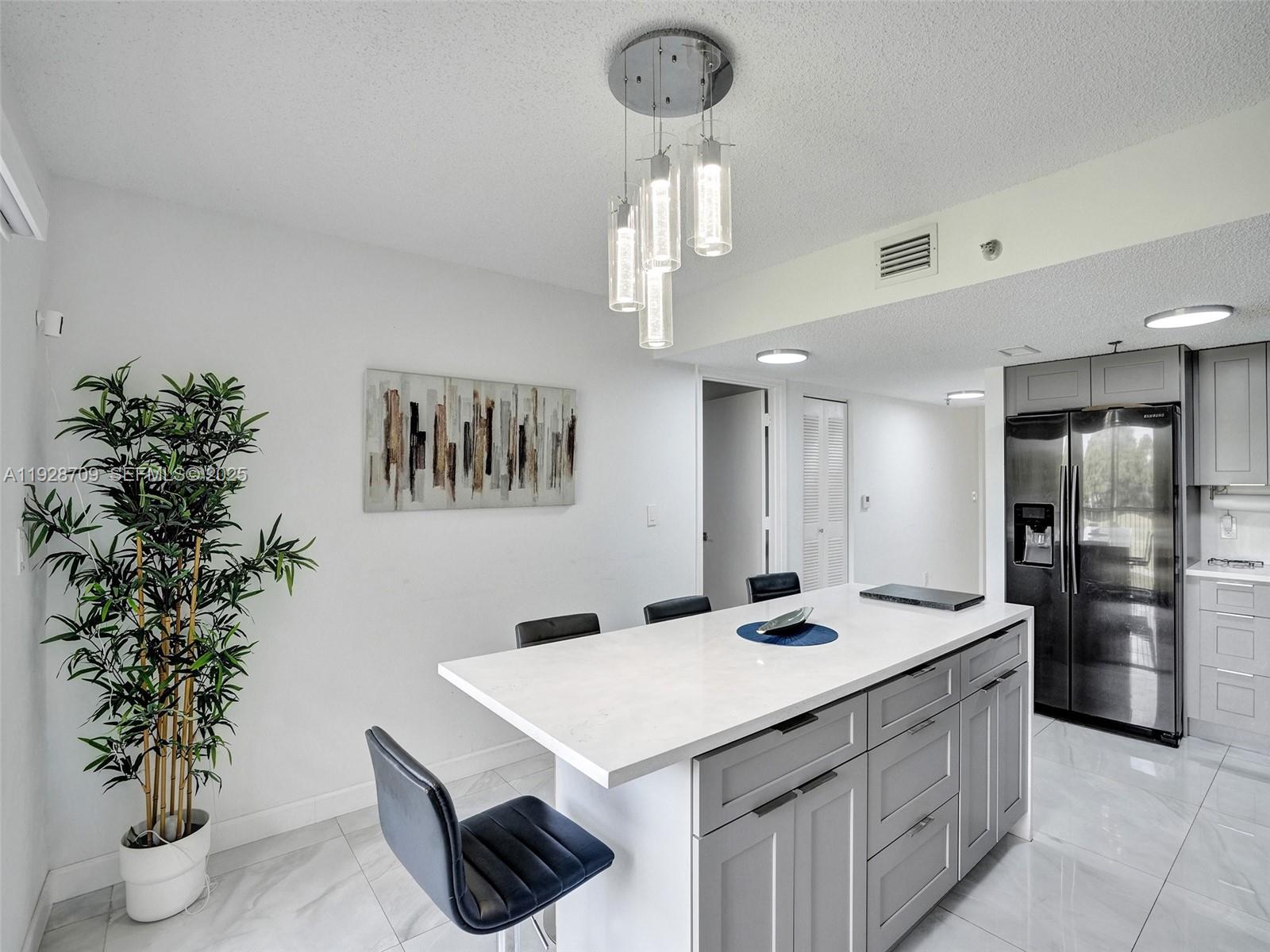 9470 Tangerine Place, Unit 207 Davie, FL 33324 - Photo 9 of 14 a kitchen with stainless steel appliances granite countertop a sink dishwasher and a refrigerator with wooden floor