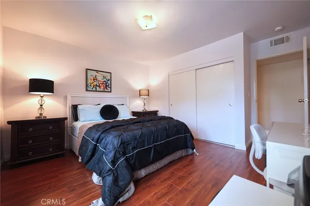 a bedroom with a bed and a flat tv screen on dresser