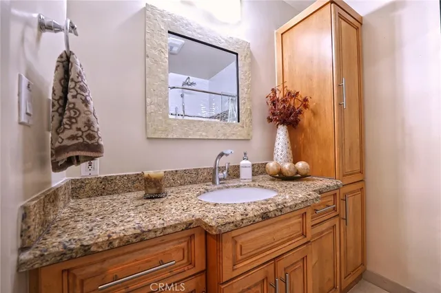a bathroom with a granite countertop sink and a mirror