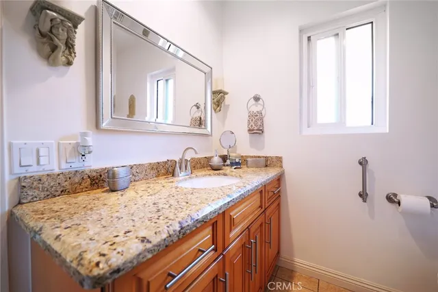 a bathroom with a granite countertop sink and a mirror