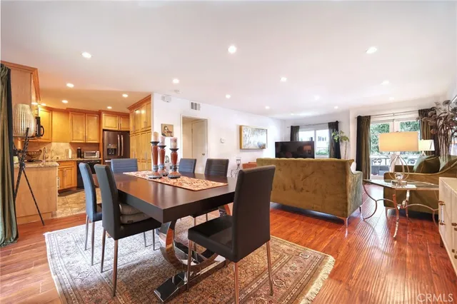 a dining room with stainless steel appliances kitchen island granite countertop a dining table chairs and view of living room
