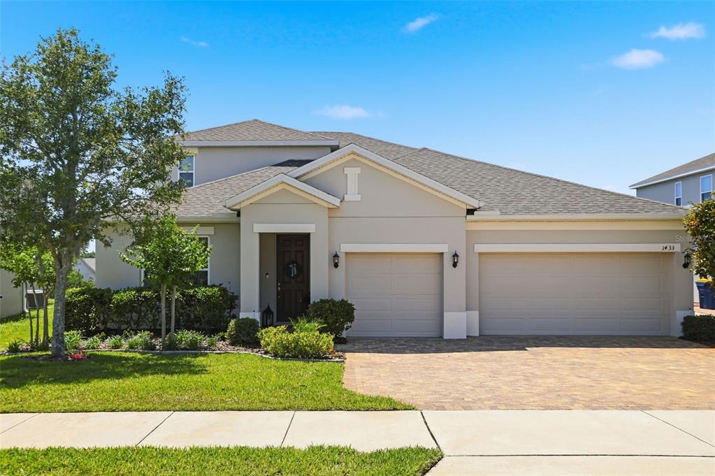 1433 Shira Road Minneola, FL 34715 - Photo 1 of 40 a front view of a house with a yard and garage