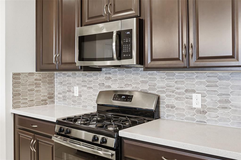 1433 Shira Road Minneola, FL 34715 - Photo 17 of 40 a kitchen with granite countertop a stove top oven
