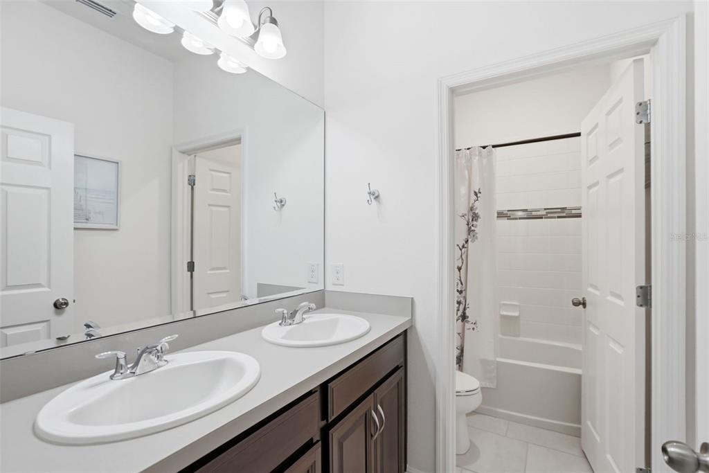 1433 Shira Road Minneola, FL 34715 - Photo 26 of 40 a bathroom with a sink a toilet a shower and a mirror