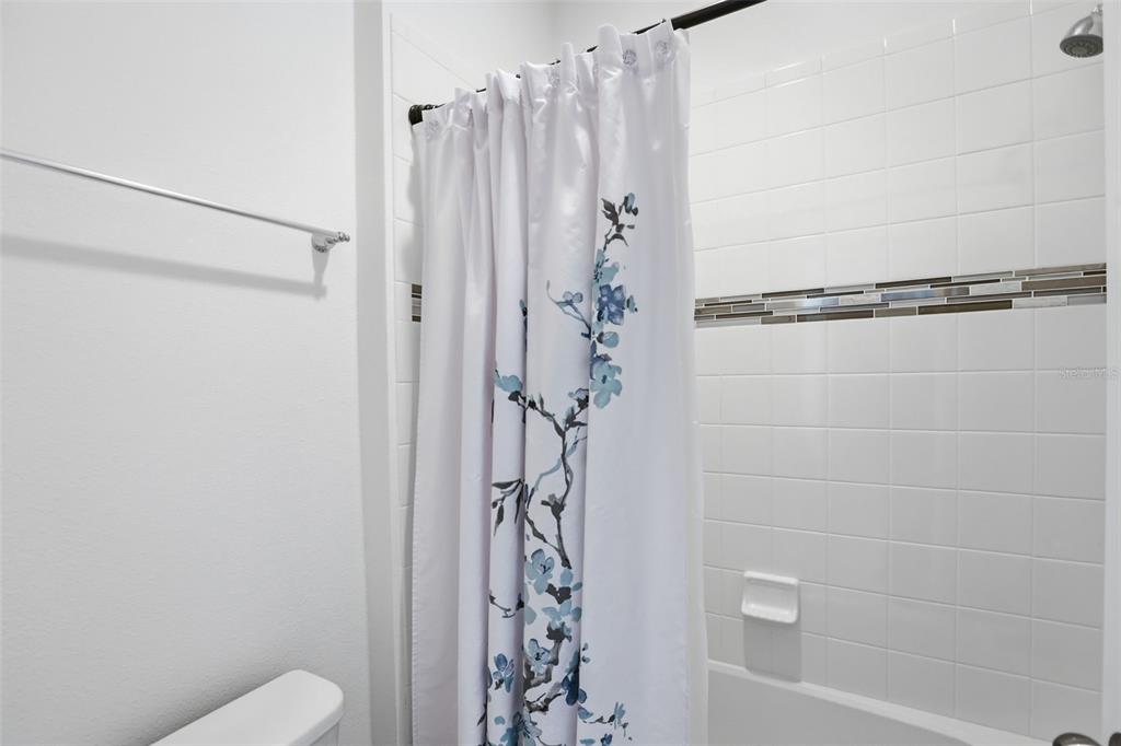 1433 Shira Road Minneola, FL 34715 - Photo 27 of 40 a bathroom with a shower curtain