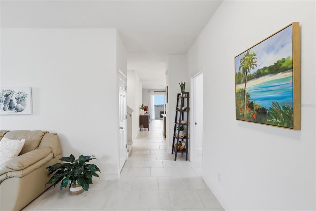 1433 Shira Road Minneola, FL 34715 - Photo 10 of 40 a hallway with a couch and a painting on the wall