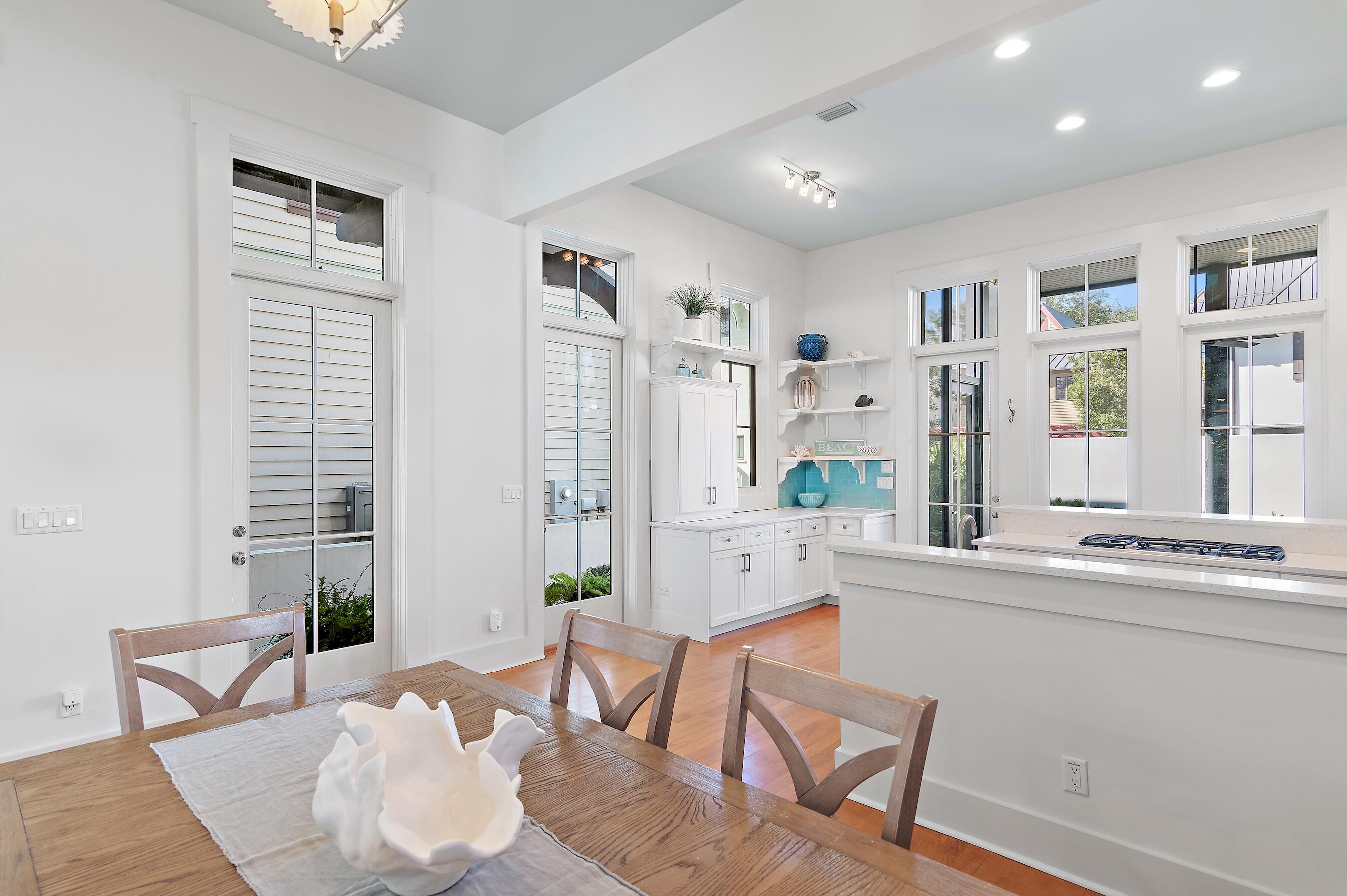182 Kingston Road Inlet Beach, FL 32461 - Photo 18 of 55 a large white kitchen with stainless steel appliances granite countertop a couch and a dining table with wooden floor