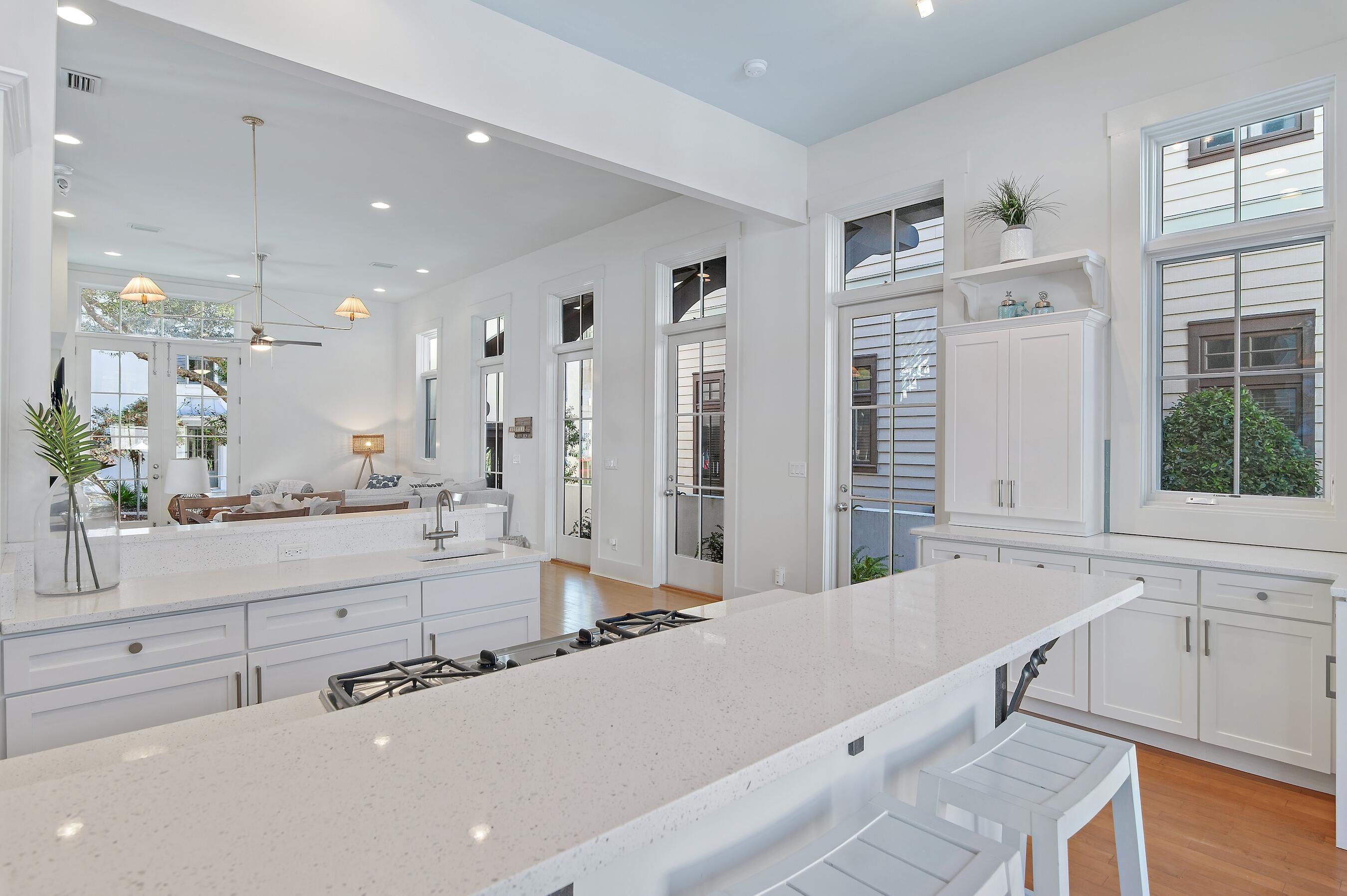 182 Kingston Road Inlet Beach, FL 32461 - Photo 4 of 55 a large white kitchen with granite countertop a sink and white cabinets with wooden floor