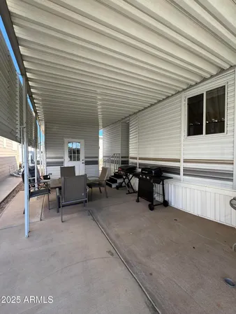 a view of a patio with table and chairs with wooden floor and fence