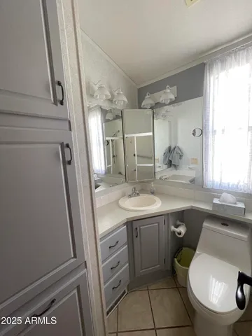 a bathroom with a toilet sink and mirror