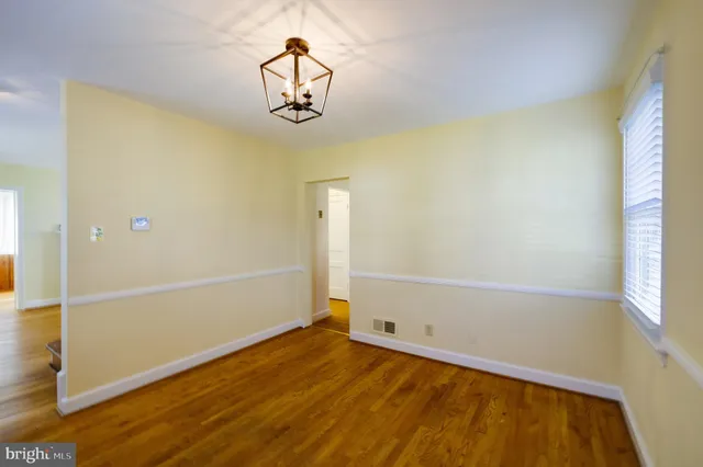 a view of a room with wooden floor and chandelier