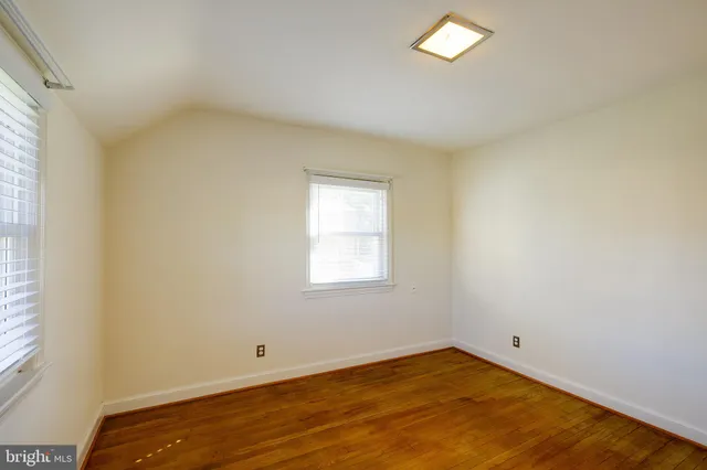 a view of a room with wooden floor and a bathroom
