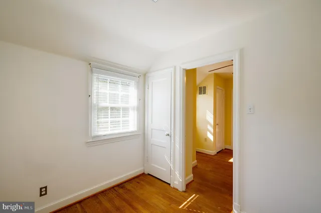 a view of a hallway with wooden floor and glass door