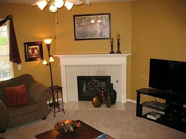 a living room with furniture a fireplace and a flat screen tv