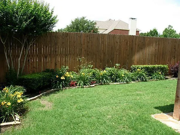 a view of a backyard with potted plants and wooden fence
