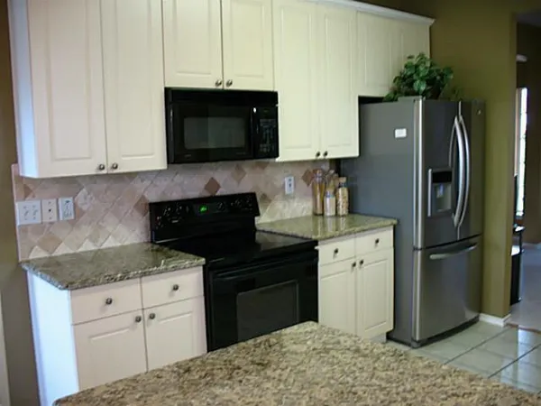 a kitchen with a refrigerator sink and cabinets