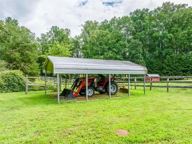 an aerial view of residential houses with outdoor space and trees all around