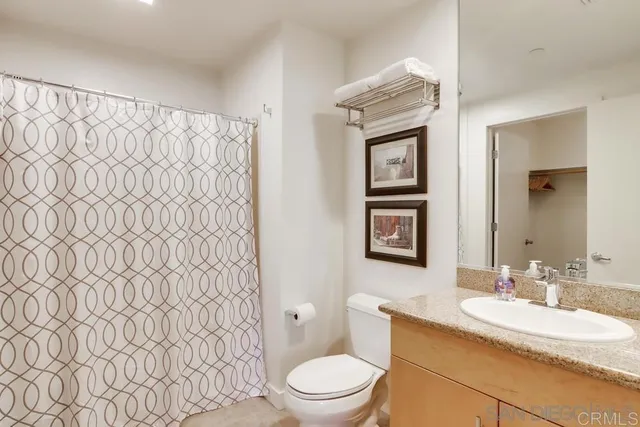 a bathroom with a granite countertop toilet sink and a mirror