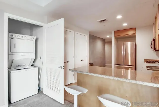 a view of a kitchen with refrigerator and wooden floor
