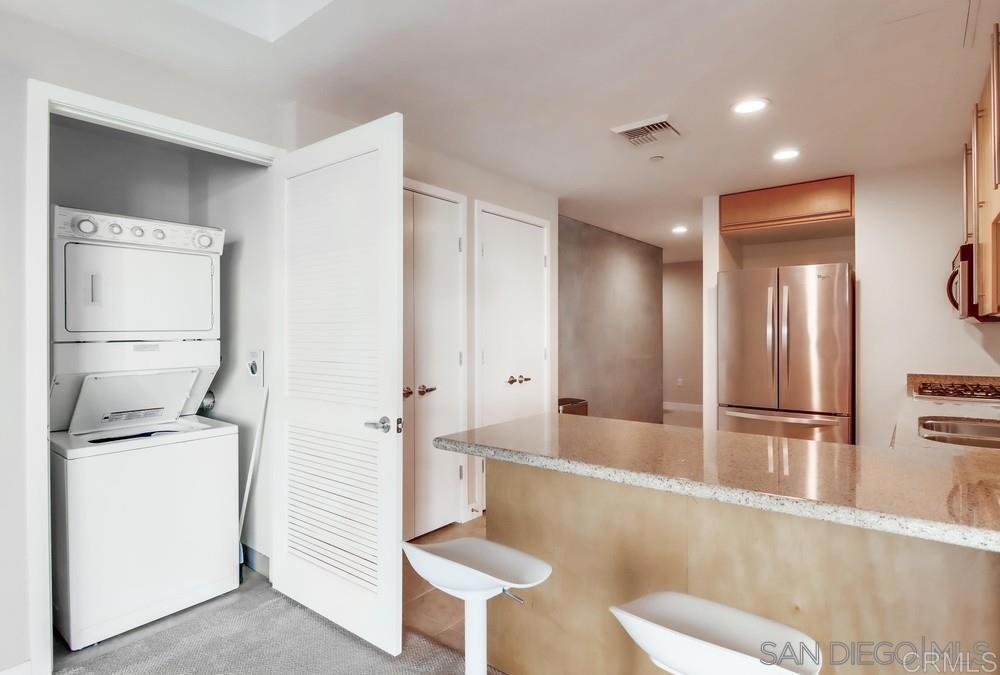 801 Ash Street, Unit 205 San Diego, CA 92101 - Photo 14 of 25 a view of a kitchen with refrigerator and wooden floor