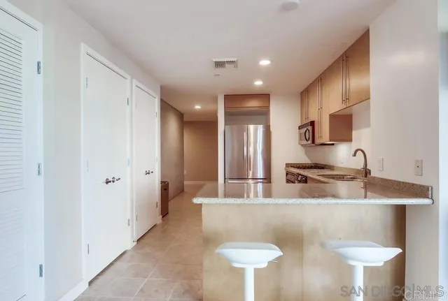 a kitchen with stainless steel appliances granite countertop a sink a stove and a refrigerator