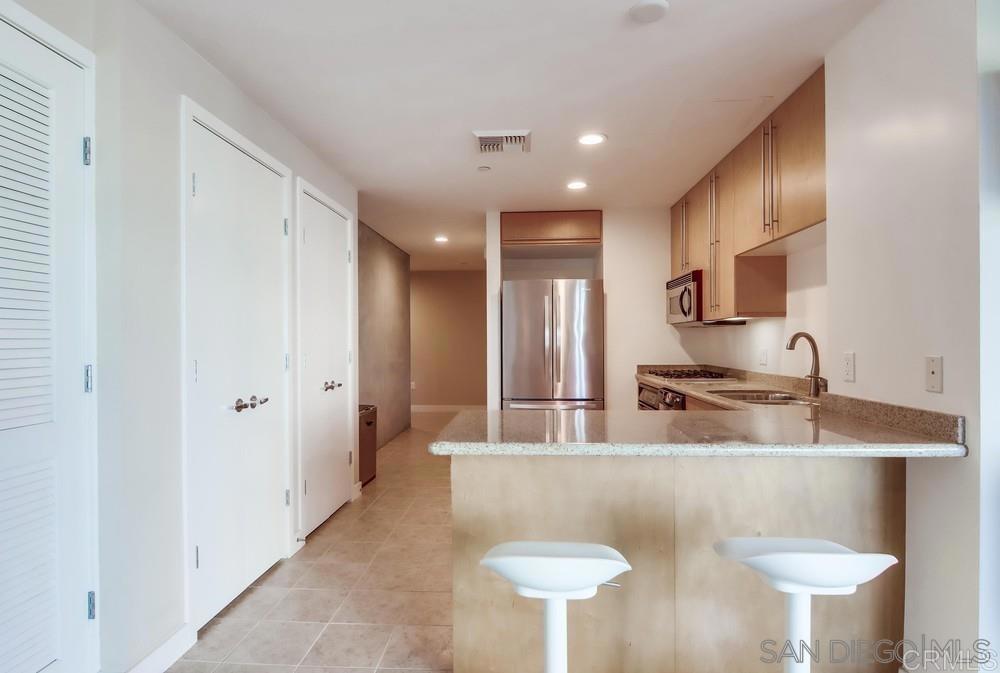 801 Ash Street, Unit 205 San Diego, CA 92101 - Photo 6 of 25 a kitchen with stainless steel appliances granite countertop a sink a stove and a refrigerator
