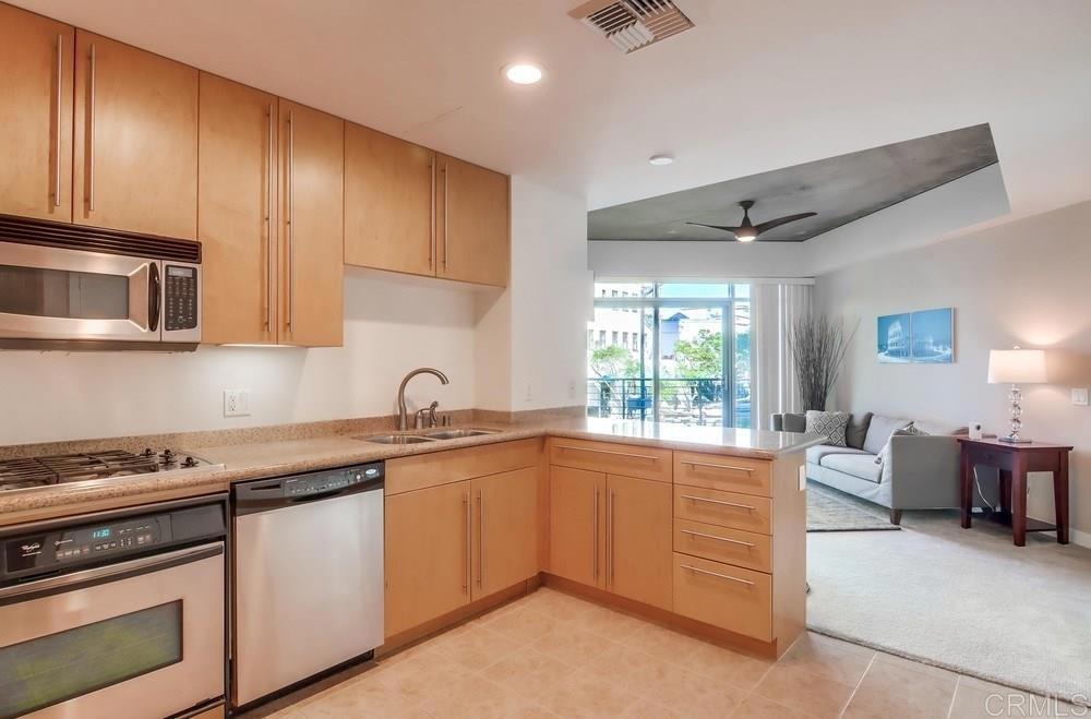 801 Ash Street, Unit 205 San Diego, CA 92101 - Photo 7 of 25 a kitchen with stainless steel appliances granite countertop a sink stove and cabinets