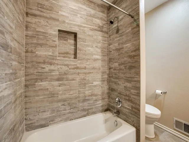 a bathroom with a toilet and a tub