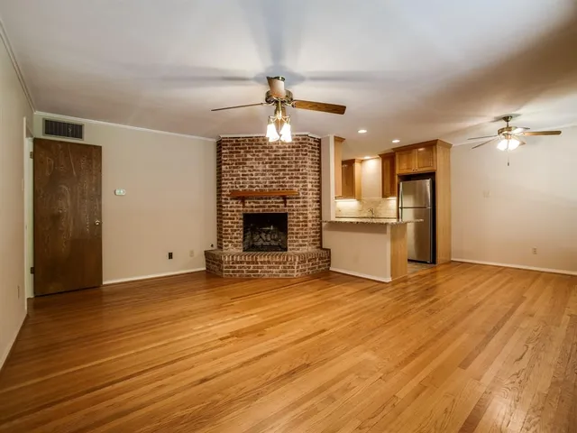 a view of a livingroom with a fireplace and chandelier fan
