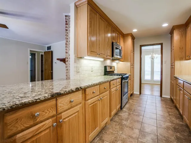 a large kitchen with stainless steel appliances lots of counter space and a sink