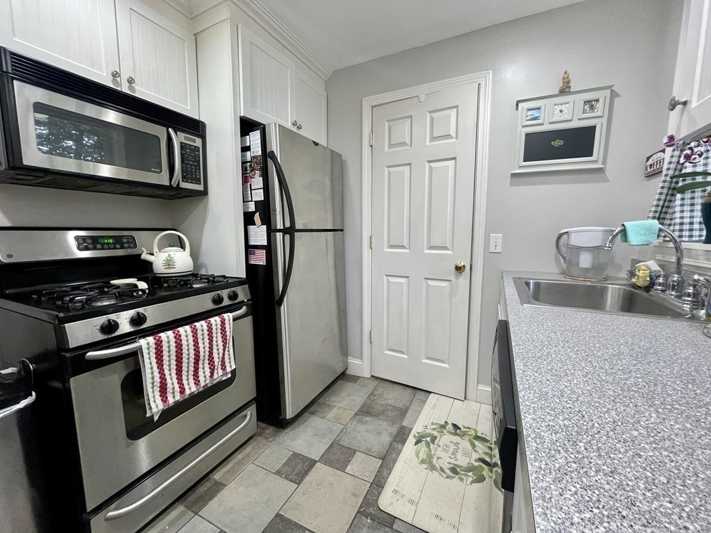 67 Colonial Road Weymouth, MA 02191 - Photo 9 of 31 a kitchen with stainless steel appliances granite countertop a stove a microwave and a refrigerator