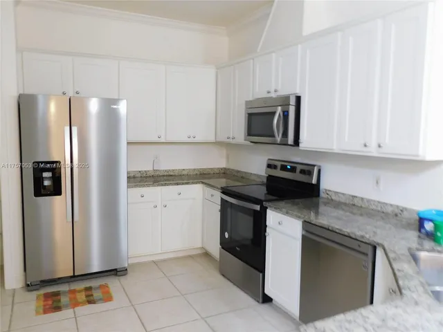 a kitchen with stainless steel appliances granite countertop a refrigerator stove and microwave