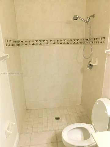 a bathroom with a granite countertop bathtub shower sink and toilet