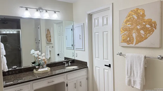 a bathroom with double vanity sinks a vanity and a mirror