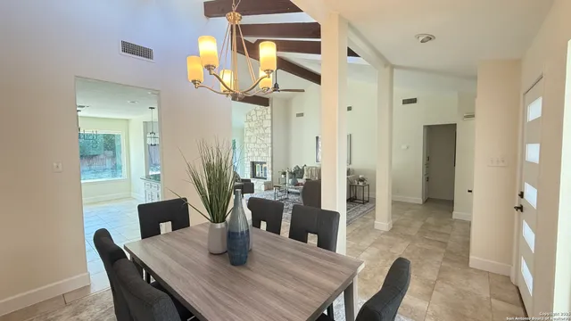 a dining room with furniture a chandelier and wooden floor