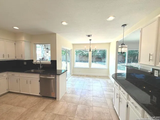 a large kitchen with stainless steel appliances granite countertop a sink and cabinets