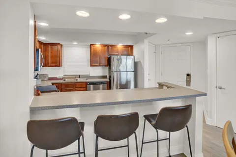 a kitchen with a dining table chairs and wooden floor