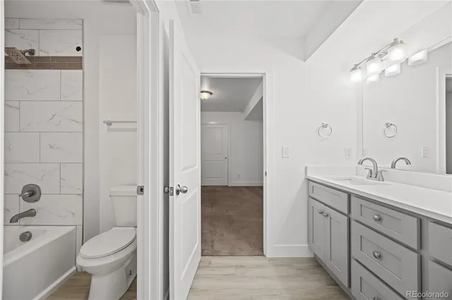 a bathroom with a toilet a sink a mirror a bathtub and shower