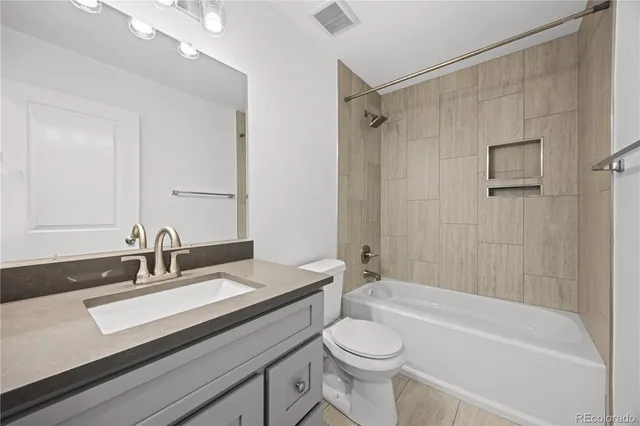 a bathroom with a sink a toilet a mirror a bathtub and shower