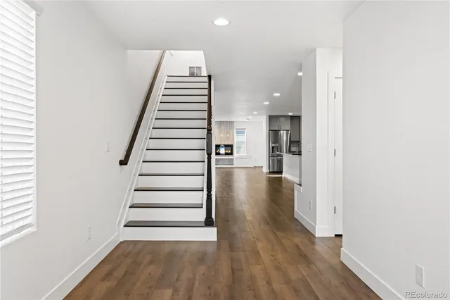 a view of a hallway with wooden floor and entryway
