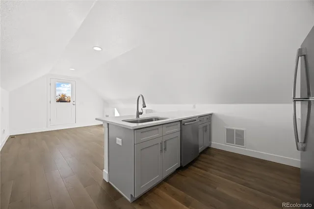 a kitchen with a sink cabinets and wooden floor