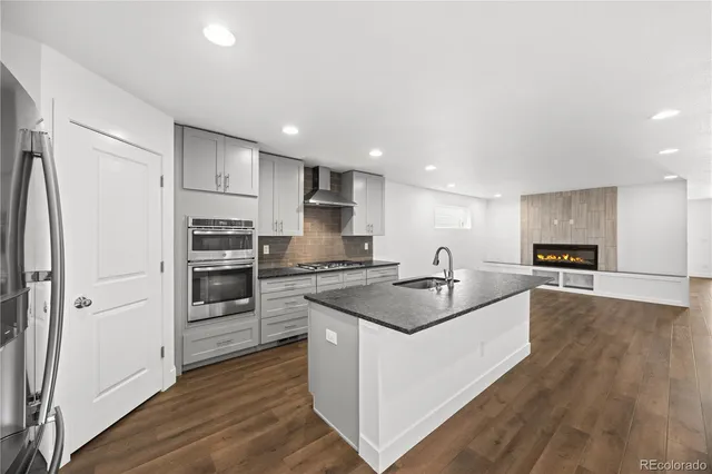 a kitchen with stainless steel appliances granite countertop a sink stove and refrigerator